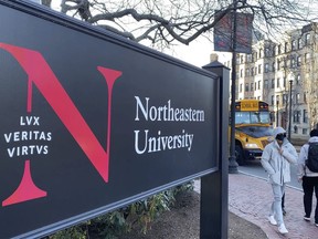 FILE - In this Jan. 31, 2019 file photo, pedestrians walk near a Northeastern University sign on the school's campus in Boston. A former lab manager at Northeastern University has been convicted, Friday, June 28, 2024, of staging a hoax explosion at the Boston campus and then lying about what happened to a federal agent.