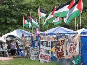 Supporters stand in front of the pro-Palestinian protest encampment on the downtown Montreal McGill University campus, Monday, June 17, 2024. McGill University says it is ending negotiations with pro-Palestinian activists at an encampment on its downtown campus.