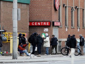 A new study examining data from the Ontario coroner's office and other sources indicates opioid-related deaths in the province's shelters more than tripled during the COVID-19 pandemic, when compared with a few years prior. People gather outside of a shelter in downtown Toronto on Saturday, March 28, 2020.