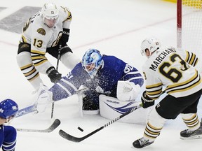 Toronto Maple Leafs' goaltender Joseph Woll (60) makes as save as Boston Bruins' Brad Marchand (63) and Charlie Coyle (13) look for a rebound during third period action in Game 6 of an NHL hockey Stanley Cup first-round playoff series in Toronto on Thursday, May 2, 2024.