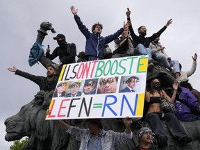 A protester holds an anti-far right banner showing the faces of French Presidents and the word 'Honte' or 'Shame' during a rally in Paris, Saturday, June 15, 2024. Anti-racism groups joined French unions and a brand-new left-wing coalition in protests in Paris and across France on Saturday against the surging nationalist far right as frenzied campaigning is underway ahead of snap parliamentary elections.