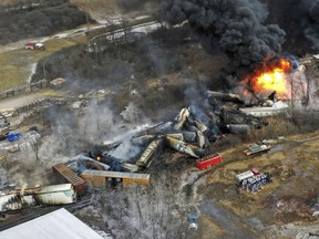 FILE - Debris from a Norfolk Southern freight train lies scattered and burning along the tracks on Feb. 4, 2023, the day after it derailed in East Palestine, Ohio. East Palestine residents will learn more Tuesday about the fiery Norfolk Southern train crash that derailed their lives last year when the National Transportation Safety Board holds another hearing in their eastern Ohio hometown to discuss what their investigation uncovered and their recommendations to prevent future disasters.