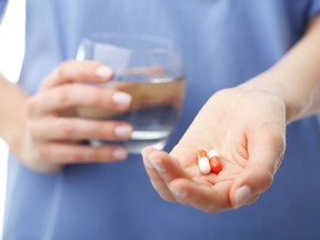 Woman holding multivitamins in her hand