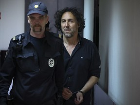 French citizen Laurent Vinatier, right, is escorted into a cage in a courtroom in the Zamoskvoretsky District Court in Moscow, Russia on Friday, June 7, 2024. A court in Moscow has ordered that the French citizen accused of collecting information on military issues in Russia be held in pre-trial custody. Vinatier was arrested in the Russian capital on Thursday as tensions have flared between Moscow and Paris following French President Emmanuel Macron's statements about the possibility of deploying the country's troops in Ukraine. (AP Photo)