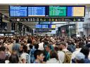 Passengers gather around the departure boards at the Gare Montparnasse train station in Paris on July 26, 2024 as France's high-speed rail network was hit by malicious acts disrupting the transport system hours before the opening ceremony of the Paris 2024 Olympic Games.