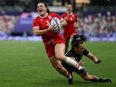 Canada's Alysha Corrigan (L) runs with the ball past New Zealand's Portia Woodman-Wickliffe (R) during the women's gold medal rugby sevens match between New Zealand and Canada during the Paris 2024 Olympic Games