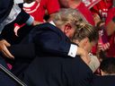 U.S. Republican presidential candidate Donald Trump is seen with a bloody ear as he is taken off the stage after an assassination attempt in Butler, Pennsylvania, on July 13, 2024.