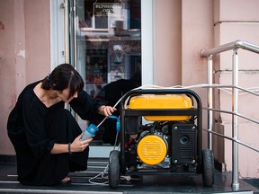 A woman in the Ukrainian resort city of Odesa uses a portable generator.