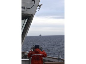 FILE -In this photo provided by the U.S. Coast Guard, a Coast Guard Cutter Kimball crew-member observes a foreign vessel in the Bering Sea, Sept. 19, 2022. A U.S. Coast Guard cutter on routine patrol in the Bering Sea came across several Chinese military ships in international waters but within the U.S. exclusive economic zone, officials said Wednesday, July 10, 2024. (U.S. Coast Guard District 17 via AP), File)