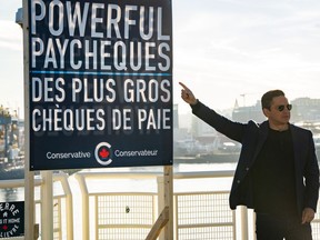 Conservative Leader Pierre Poilievre points to a campaign sign during a news conference in Vancouver on October 13, 2023.
