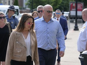 Paul O'Keefe, center, brother of the late Boston police Officer John O'Keefe, enters Norfolk Superior Court with his wife Erin O'Keefe, front left, Monday, July 1, 2024, in Dedham, Mass. Read is on trial, accused of killing her boyfriend John O'Keefe, in 2022. The jury began deliberations in the trial Tuesday, June 25.