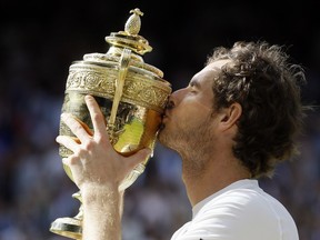 FILE - Andy Murray of Britain kisses his trophy after beating Milos Raonic of Canada in the men's singles final on day fourteen of the Wimbledon Tennis Championships in London, Sunday, July 10, 2016. Murray will play only doubles at his last appearance at the All England Club following his withdrawal from singles after back surgery.