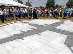 FILE - Family members and others look at a monument honoring the 15 Marines and one Navy corpsman who died in a July 10, 2017, U.S. military plane crash near Itta Bena, Miss., during an unveiling ceremony for the monument on July 14, 2018. Federal prosecutors said Wednesday, July 3, 2024, that a former engineer at a U.S. military air logistics center has been charged with making false statements and obstructing justice during the criminal investigation into the crash of the plane that had the call sign "Yanky 72."