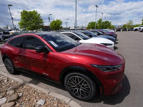 FILE - A line of unsold 2024 Mustang Mach-E electric utility vehicles sit at a Ford dealership May 19, 2024, in Denver. On Tuesday, July 2, 2024, automakers will report second-quarter U.S. sales and they're expected to be flat compared with a year ago.