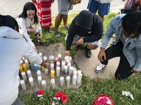 People light candles on the sidewalk during a vigil for 13-year-old Nyah Mway in Utica, N.Y., Saturday, June 29, 2024. On Friday, June 28, Mway was fatally shot by police who'd tackled him to the ground after he allegedly pointed what turned out to be a BB gun at them during a foot chase.