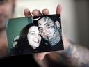Bryon Widner holds a photo at his home of him and Julie Miller taken before his facial tattoos were removed.