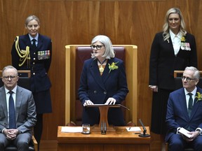 Governor-General of Australia Sam Mostyn, center, speaks during the swearing in ceremony in the Senate chamber at Parliament House in Canberra, Monday, July 1, 2024, as Prime Minister Anthony Albanese, left, listens. Mostyn is Australia's second woman governor-general, a largely ceremonial role representing the British monarch as the nation's head of state.