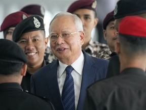 FILE - Former Malaysian Prime Minister Najib Razak arrives at the Kuala Lumpur High Court complex escorted by prison officers in Kuala Lumpur, Malaysia, Thursday, April 4, 2024. A Malaysian court Wednesday, July 3, 2024, dismissed a bid by imprisoned former Prime Minister Najib Razak to serve his remaining corruption sentence under house arrest.