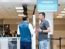 Passengers are seen in the WestJet check-in area at Pearson International Airport, in Toronto, Saturday, June 29, 2024.