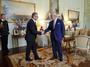 Britain's King Charles III, right, shakes hands with Keir Starmer where he invited the Labour Party leader to become prime minister and to form a new government, following the landslide general election victory for the Labour Party, in London, Friday, July 5, 2024.