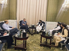 In this photo released by the Taliban Spokesman Office, Zabihullah Mujahid, the chief spokesman for the Taliban government who leads the Taliban delegation, center right, speaks with Russian Presidential Envoy to Afghanistan Zamir Kabulov, during a meeting in Doha, Qatar, Sunday, June 30, 2024. A Taliban delegation is attending a United Nations-led meeting in Qatar on Afghanistan after organizers said women would be excluded from the gathering. The two-day meeting is the third U.N.-sponsored gathering on the Afghan crisis. (Taliban Spokesman Office via AP)