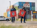 Saskatoon rail workers hold Teamsters Canada Rail Conference signs while picketing at the CN Chappell Yards after being locked out Thursday.