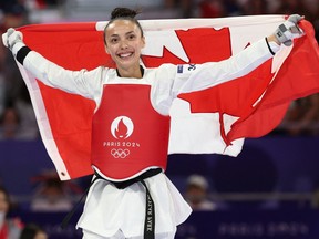 Canada's Skylar Park celebrates with her country's flag after winning in the taekwondo women's -57kg bronze medal bout of the Paris 2024 Olympic Games.