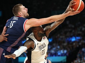 Nikola Jokic #15 of Team Serbia and Lebron James #6 of Team United States contest for a rebound during a Men's basketball semifinals.
