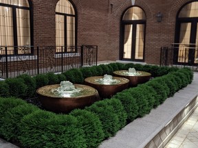 A water feature can be used to break up monotonous interlocking and plantings. Here, recirculated water spills over decorative bowls.
