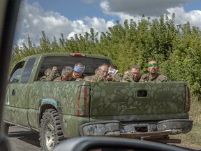 A pickup truck was carrying several blindfolded men.