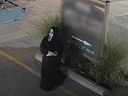 An image taken from video shows a person wearing a mask and robes walks away after spray painting a sign in Vaughan, Ont. Police say the person wrote anti-Israel messages on several businesses and a synagogue.