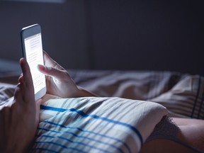 Woman using phone late at night in bed.