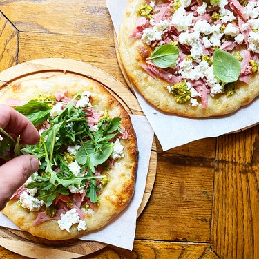 Ema Costantini's pizza topped with mortadella, stracciatella, pistachio, pesto, basil and arugula.