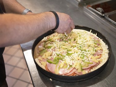 Spero Milios, Houston Pizza’s director of operations, makes the highly ordered all-dressed pizza inside one of the family business’s Regina locations.