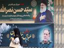 A woman walks past banners in Tehran bearing pictures of slain Lebanese Hezbollah leader Hassan Nasrallah (top) and Iran's paramilitary Revolutionary Guard general Abbas Nilfrushan, two days after their targeted assassination by Israeli forces in Beirut's southern suburbs, on September 29, 2024.