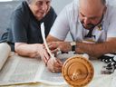 Jonny Daniels helps Holocaust survivor Kitty Salsberg fill out a letter in a Torah in Toronto, Ont. on Sept. 30, 2024. The Torah was hidden by a rabbi in a Polish village in 1939. It is being restored by Holocaust survivors around the world.