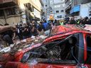 check the destruction in a street under a residential building whose top two floors were hit by an Israeli strike in the Ghobeiri area of Beirut's southern suburbs on September 24, 2024.