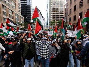 Protesters carry Palestinian flags down a Toronto street.