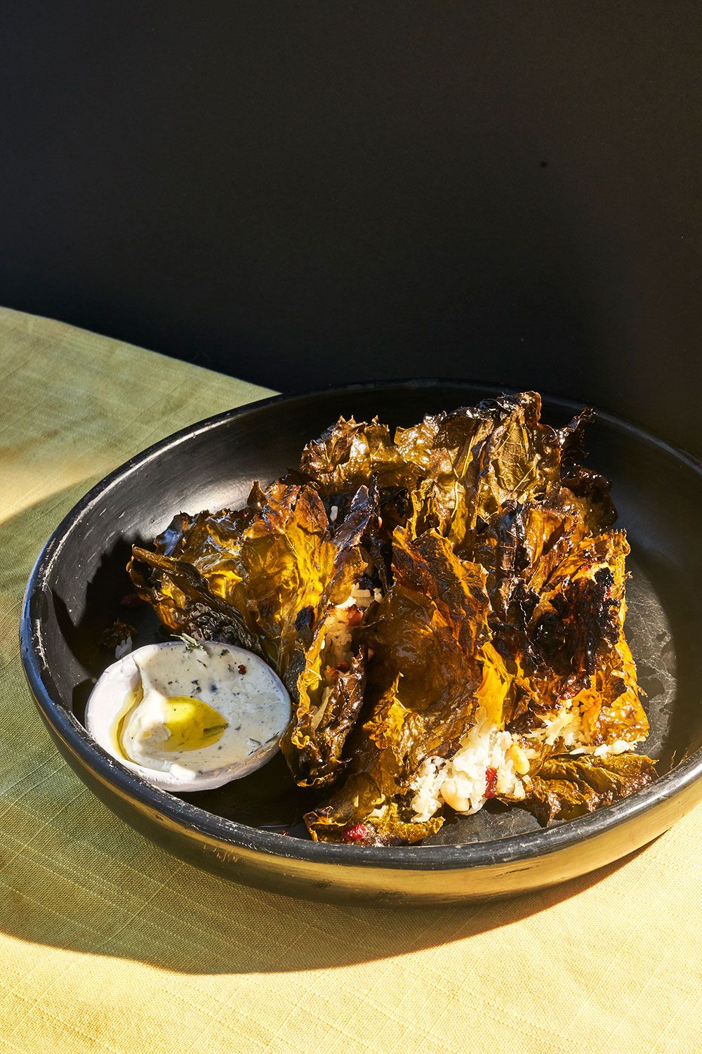 Stuffed crispy grape leaves with curry leaf yogurt and pine nuts