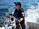 Sailor Third Class Kali Alexander steering a sailing vessel this summer during her time with Canada's Naval Experience Program.
