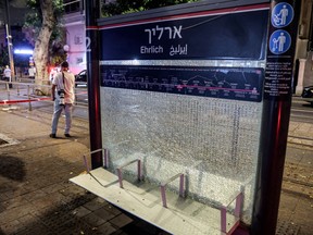 A photojournalist stands near the damaged Ehrlich station of the Tel Aviv Light Rail at the scene of a shooting attack in Jaffa south of Tel Aviv on Oct. 1, 2024.