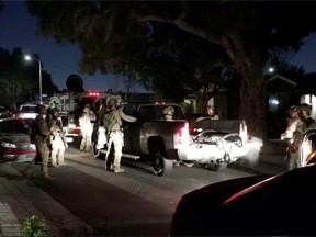 FBI agents search vehicles at night.