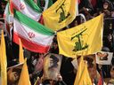 Demonstrators wave Iran and Hezbollah flags and carry portraits of slain leaders, including Lebanon's late Hezbollah chief Hassan Nasrallah, during a rally in Tehran on Oct. 2, 2024, a day after Iran fired a barrage of missiles at Israel.