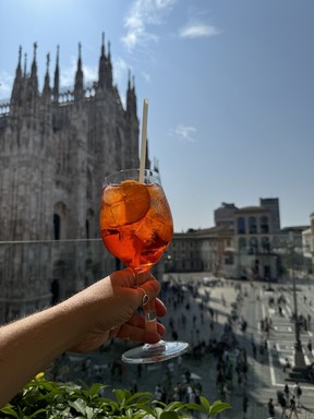 Enjoying an Aperol Spritz overlooking the Duomo cathedral in Milan.
