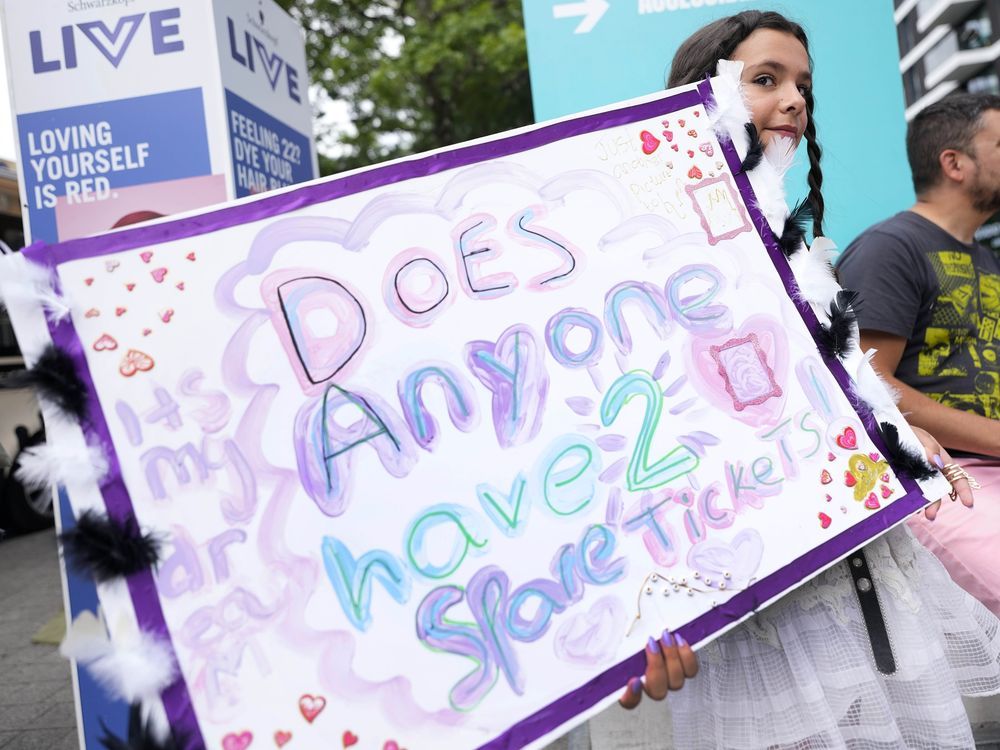 A fan of Taylor Swift holds a sign