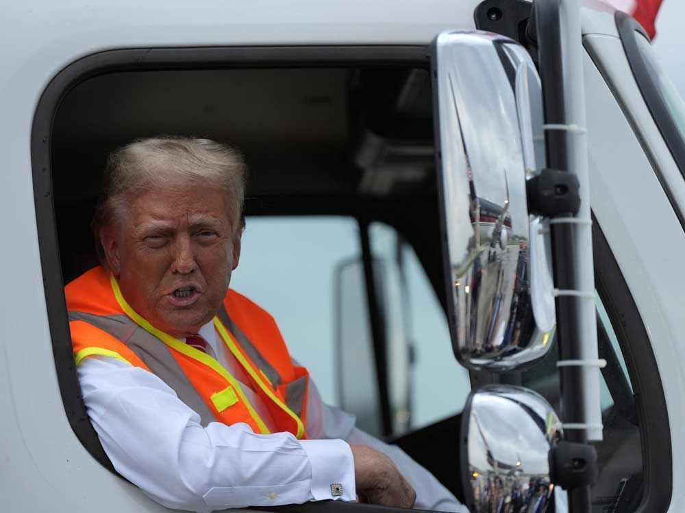 NextImg:Safety vest-clad Trump hops in garbage truck following Biden's comment about his supporters