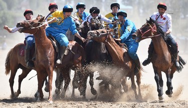 Russian and Kazakh, in white and blue, respectively, play buzkashi or kok-boru at the 2018 World Nomad Games in Kyrgyzstan.