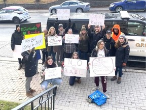 Protestors hold signs outside a court in Temiskaming