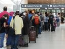 People line up before entering the security zone at Pearson International Airport in Toronto on Friday, August 5, 2022.