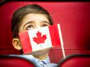 A 7-year-old boy holds his flag during a citizenship ceremony in Ottawa on Jan. 18, 2020.